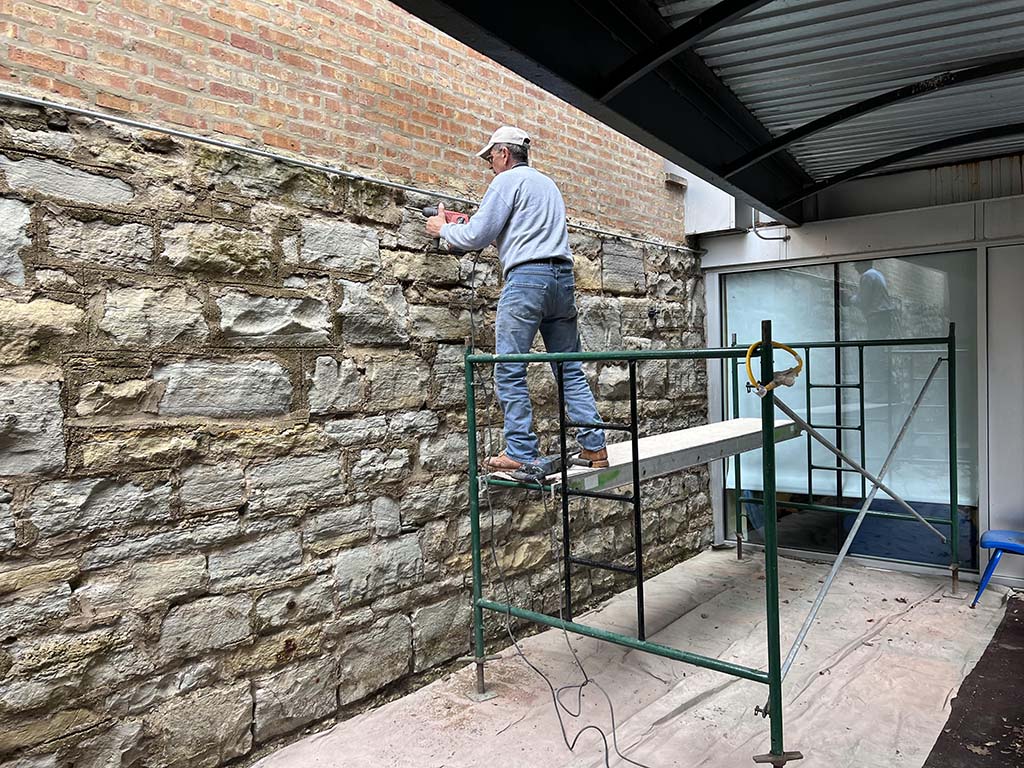 man working on split faced block wall
